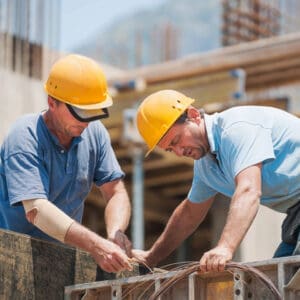 Two men in hard hats working on a construction site.